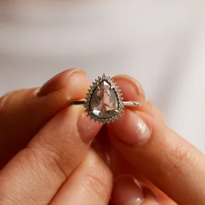 Halo prsten NOEMI se salt and pepper diamantem držený mezi prsty
