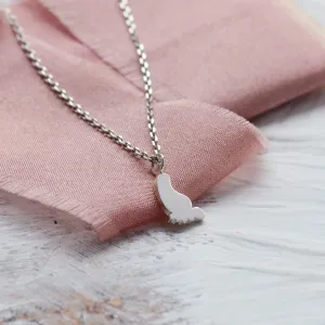 Detailní šikmý pohled na zlatý přívěsek ve tvaru dětské nohy BABY
