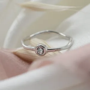 Close-up of the NOLLAIG engagement ring and bezel-set diamond