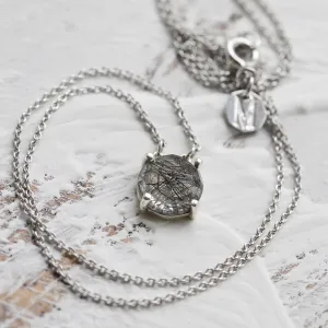 Gold MACHA necklace laid out with its rose cut rutile quartz pendant