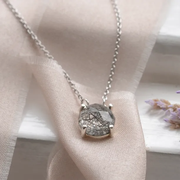 Close-up of the MACHA gold necklace pendant with rose cut rutile quartz