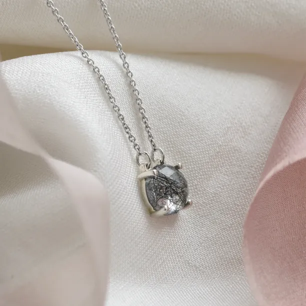 Angled view of the MACHA gold necklace pendant with rose cut rutile quartz