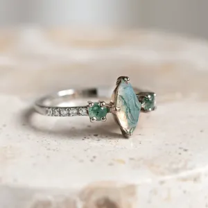 Angled view of the OSCAR ring showing its marquise moss agate and diamond-set band