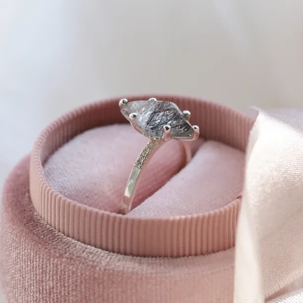 Angled view of the MAIREAD gold ring showing its rutilated quartz setting