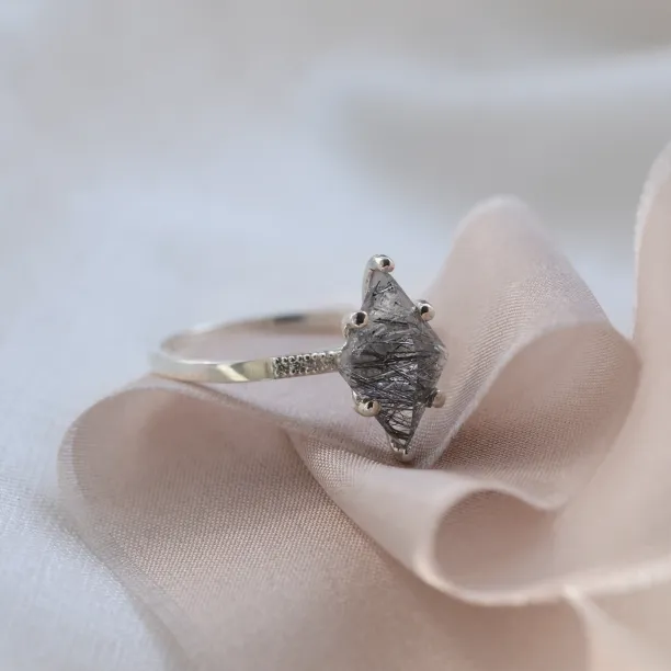 Angled view of the MAIREAD gold ring with its rutilated quartz centerpiece