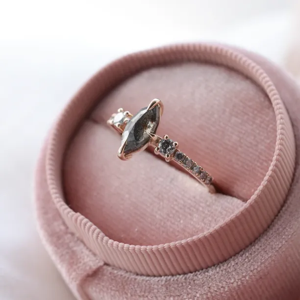Angled close-up of the ROISIN gold ring with a marquise salt and pepper diamond