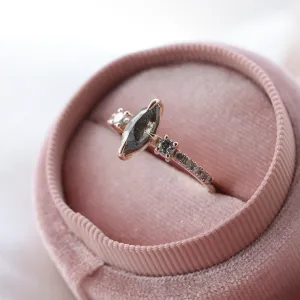 Angled close-up of the ROISIN gold ring with a marquise salt and pepper diamond