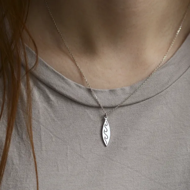 Stříbrný přívěsek s gravírem vln nošený na krku