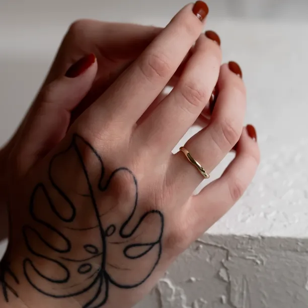 LUANA irregular gold wedding ring worn on a hand