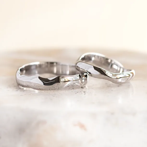 Close-up of LUANA white gold wedding rings with irregular surfaces