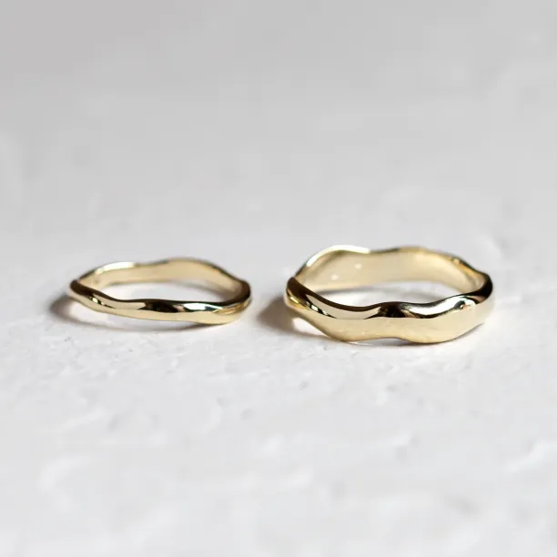 LUANA gold wedding rings shown separately with irregular surfaces