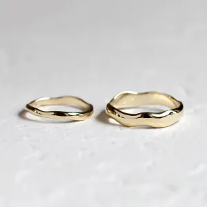 LUANA gold wedding rings shown separately with irregular surfaces