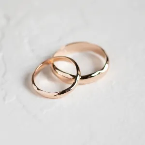 LUANA irregular gold wedding rings shown together in an angled close-up