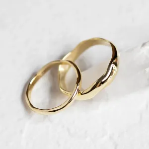 Angled close-up of the LUANA pair of irregular gold wedding rings