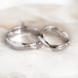 LUANA pair of irregular gold wedding rings shown from a low angle