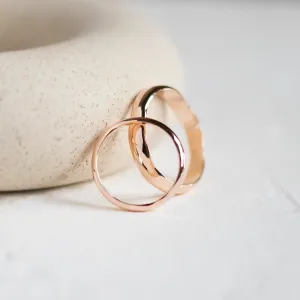 Angled view of the LUANA pair of irregular gold wedding rings