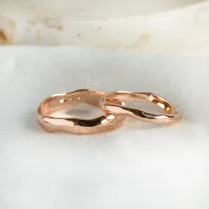 Close-up of LUANA irregular gold wedding rings with a textured surface