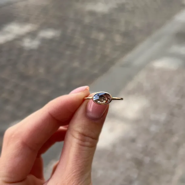 Zlatý prsten KARLIN s oválným salt and pepper diamantem držený mezi prsty