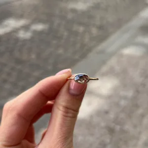 Zlatý prsten KARLIN s oválným salt and pepper diamantem držený mezi prsty
