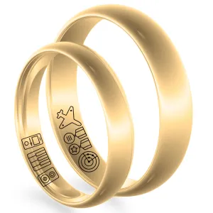 Angled view of gold wedding rings showing engraved symbols on the inner bands