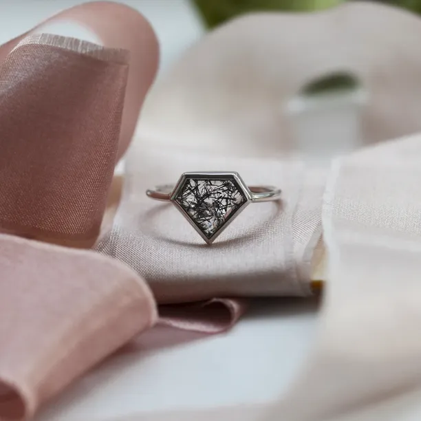 Close-up of the gold ALMONTE ring with rutile quartz and black inclusions