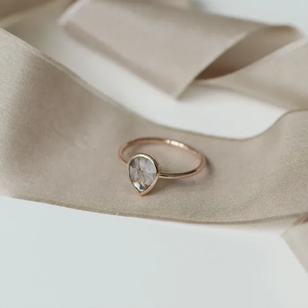Angled view of the gold XENA ring and its salt and pepper diamond