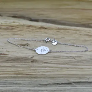 Šikmý pohled na stříbrný náramek s kompasem a diamantem