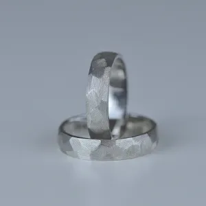 BOME platinum wedding rings with textured bands, one ring standing upright