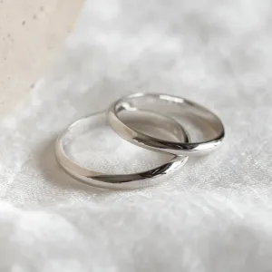 Close-up of two overlapping platinum wedding rings