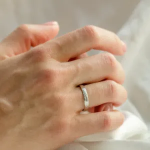 DRIS gold wedding ring worn on the hand, shown in close-up
