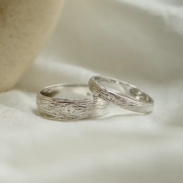 Close-up of DRIS white gold wedding rings with textured surfaces