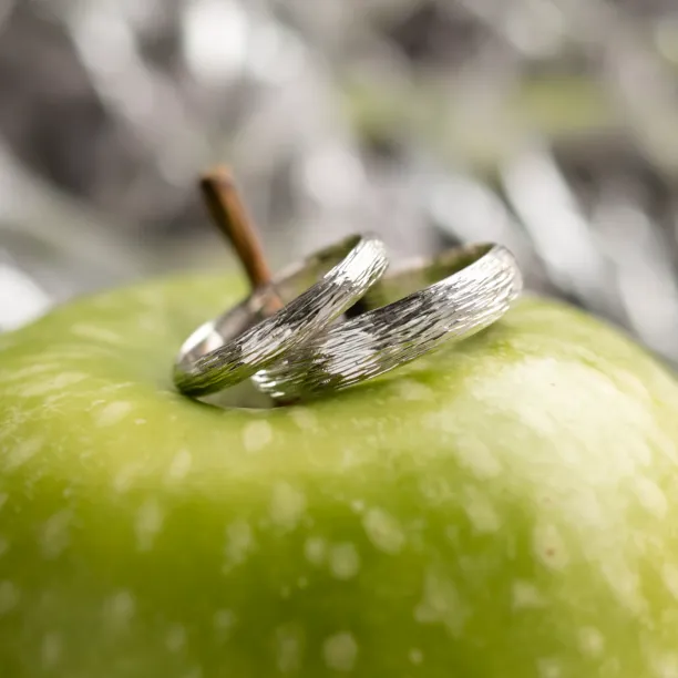 DRIS gold wedding rings with textured bands shown in close-up