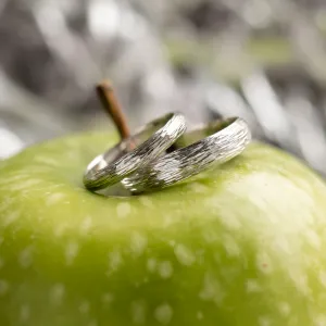DRIS gold wedding rings with textured bands shown in close-up
