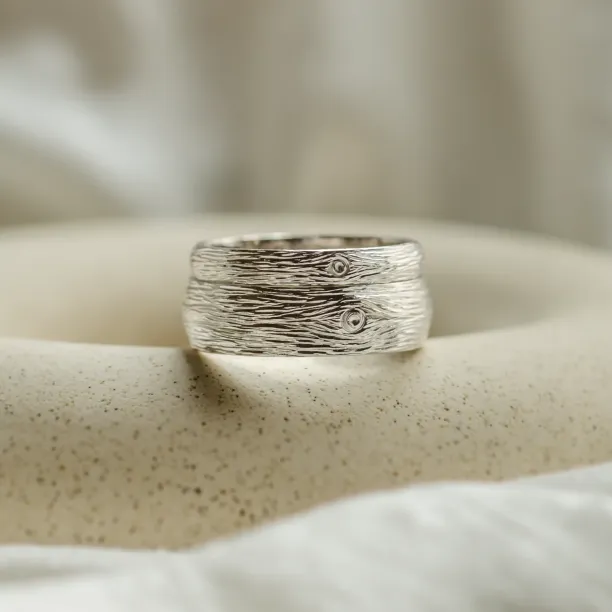 Close-up of a DRIS gold wedding ring with textured surface detail
