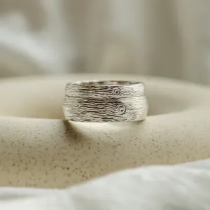 Close-up of a DRIS gold wedding ring with textured surface detail