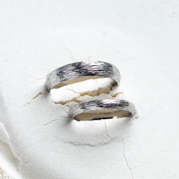 Pair of DRIS gold wedding rings showing their textured surfaces
