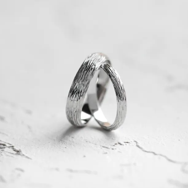 Angled view of DRIS gold wedding rings with tree-inspired texture