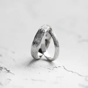Angled view of DRIS gold wedding rings with tree-inspired texture