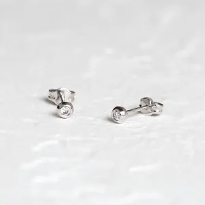 Angled view of ANY gold stud earrings with diamonds and butterfly backs
