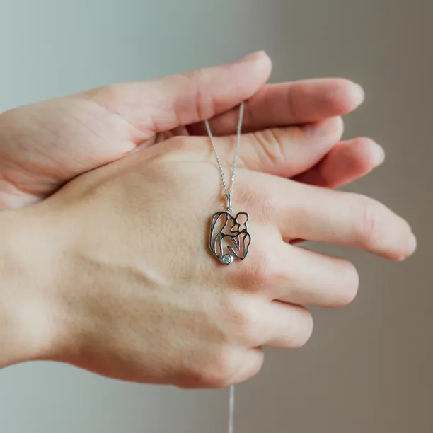 Zlatý přívěsek MOMMY s diamantem držený v ruce