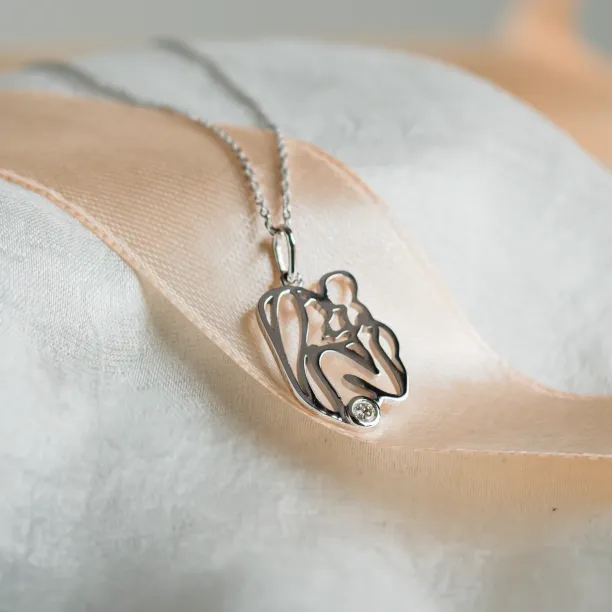 Detailní šikmý pohled na zlatý přívěsek MOMMY s viditelným diamantem