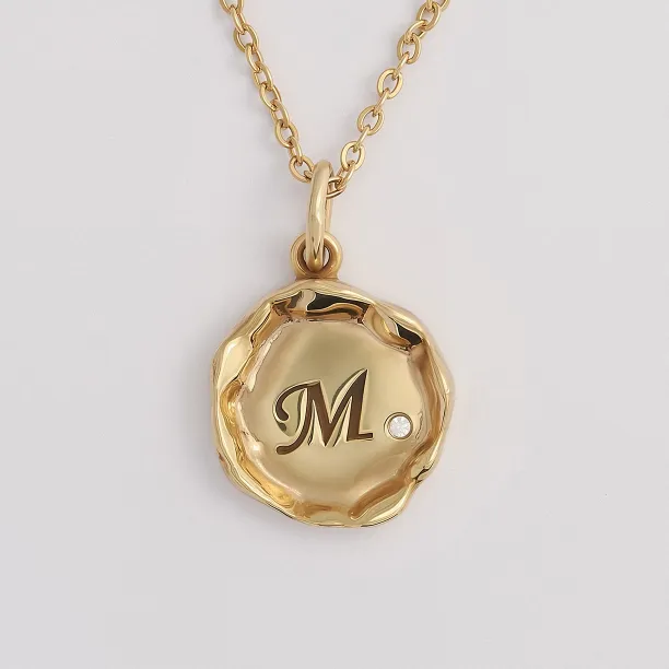 Close-up of the COLETTE diamond pendant with engraved M