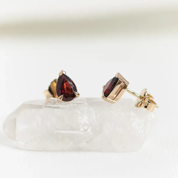Angled view of CARLIE gold earrings showing pear-shaped garnets and their backs