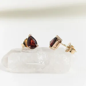 Angled view of CARLIE gold earrings showing pear-shaped garnets and their backs