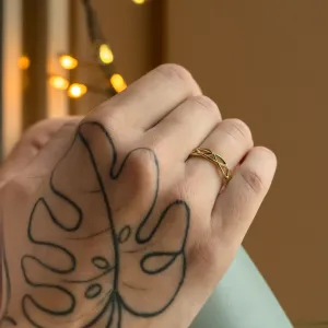 Gold diamond twisted ring worn on a hand in close-up