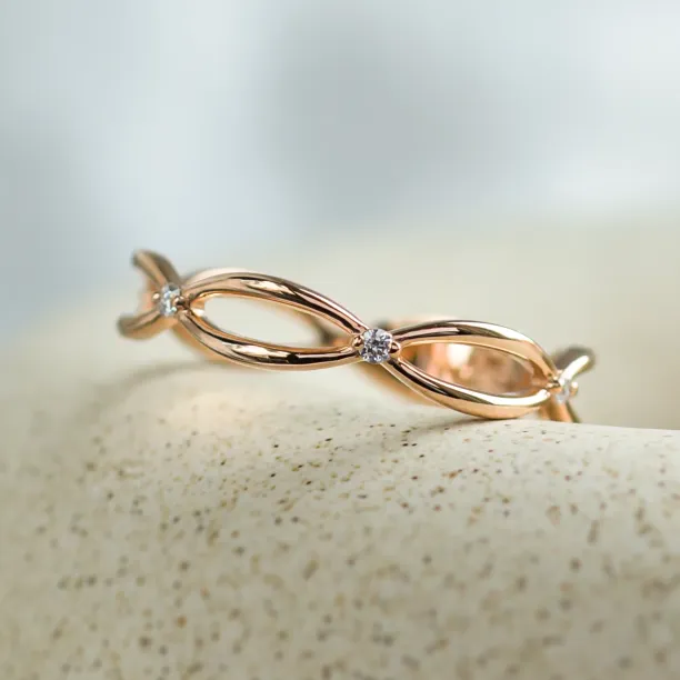 Close-up of the intertwined bands and diamonds on a gold ring