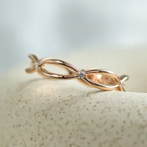 Close-up of the intertwined bands and diamonds on a gold ring