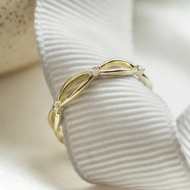 Angled close-up of the intertwined gold ring with diamonds
