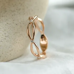 Vertical close-up of the intertwined gold ring with diamonds