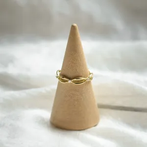 Gold diamond twisted ring displayed on a ring cone